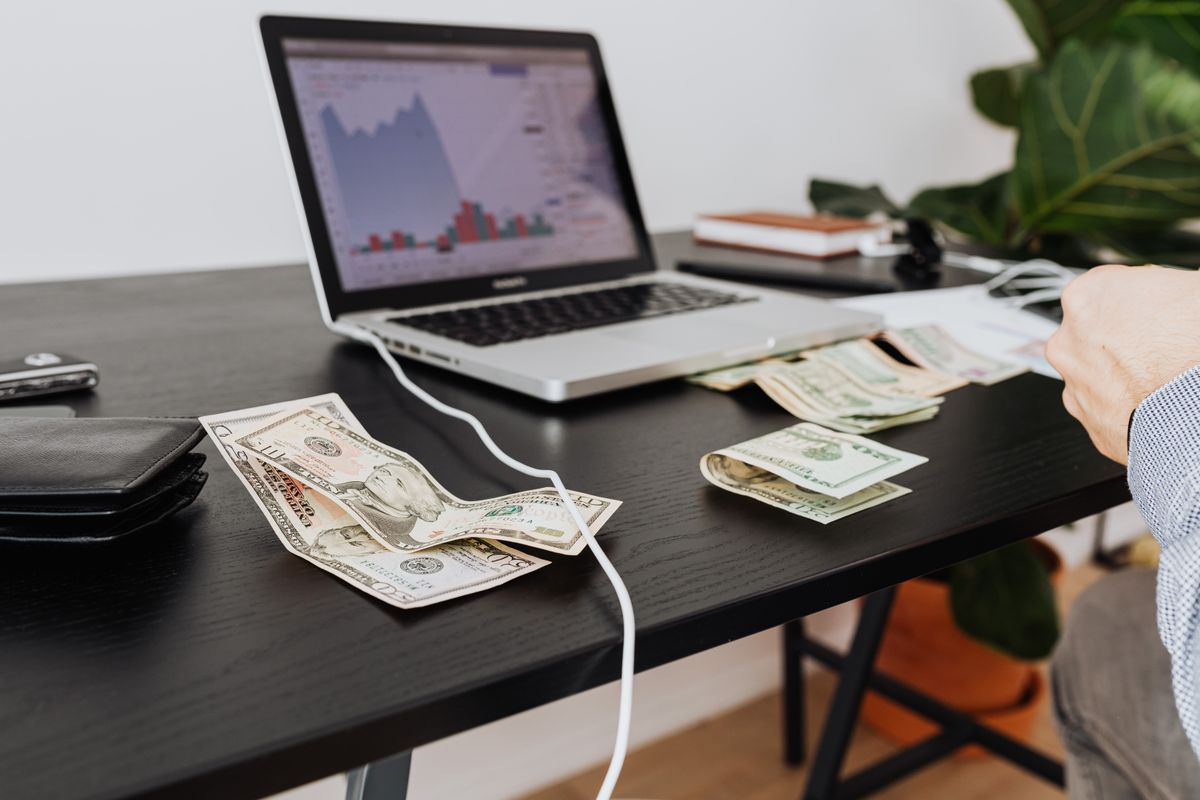 Masada nakit para, dizüstü bilgisayar ve finansal grafik — Türkiye'de fon tasfiyesi sonrası yatırımcı rotası ve likidite analizi